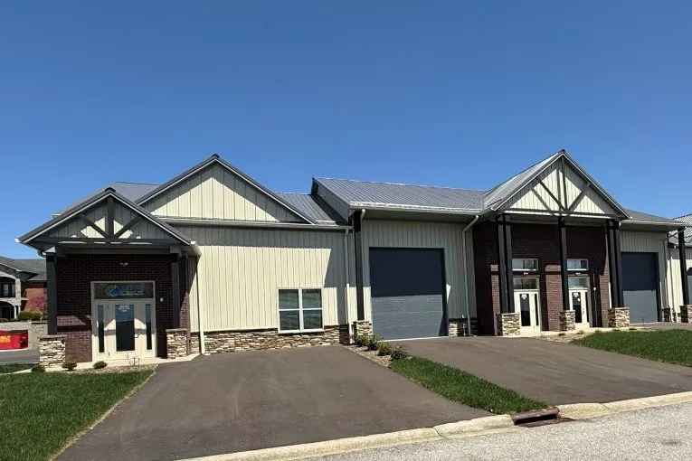 Office-warehouse frontage with gabled office entrances, overhead doors, and paved driveways