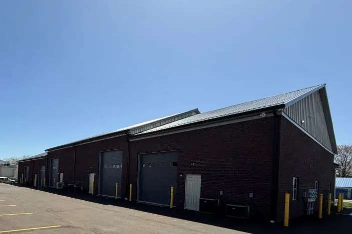 Rear warehouse exterior with overhead doors and a paved loading area